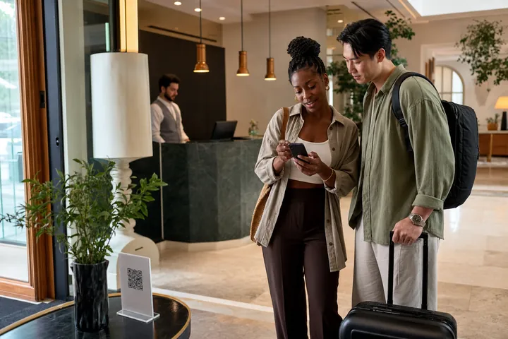 International travelers using a multilingual QR catalog in a European boutique hotel